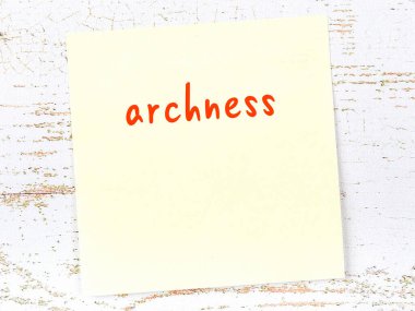 Tahta duvarda, el yazısıyla yazılmış okçuluk yazılı sarı yapışkan bir not.