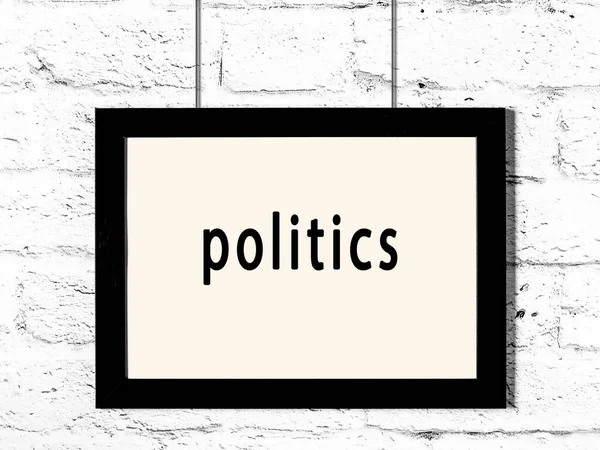 白色砖墙上挂着政治题词的黑色木制框架 — 图库照片