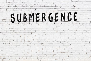 Üzerinde siyah boya bulunan beyaz tuğlalı bir duvar.