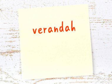 Tahta duvarda el yazısıyla yazılmış verandalı sarı yapışkan bir not.