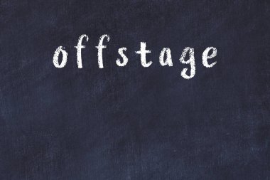 Sahne arkasında el yazısıyla yazılmış bir yazı tahtası.