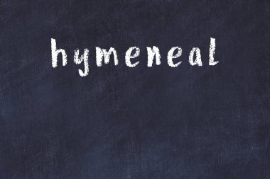 Tebeşir el yazısıyla yazılmış kızlık zarını siyah masaya.