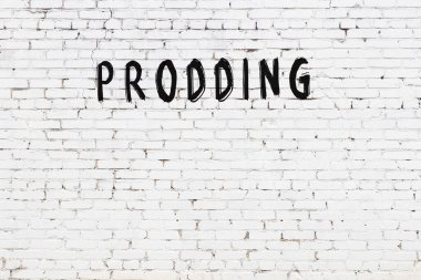 Üzerinde yazı olan beyaz tuğla duvar. Siyah boyayla elle yazılmış.