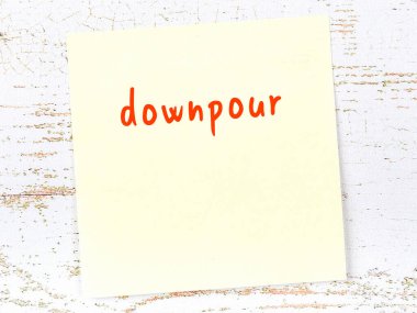 Tahta duvarda, el yazısıyla yazılmış sağanak yağışlı sarı not.