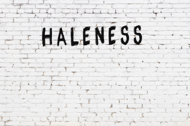 Yazılı beyaz tuğla duvar. Siyah boyayla yazılmış kutsallık.