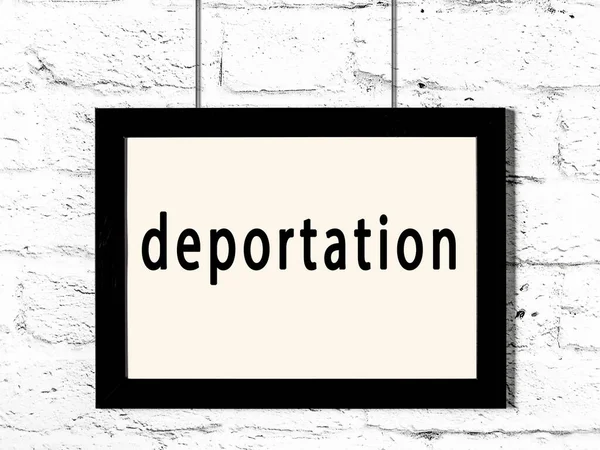 Černý Dřevěný Rám Nápisem Deportace Visí Bílé Cihlové Zdi — Stock fotografie