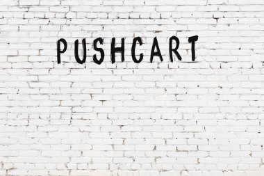 Yazılı el arabası beyaz duvarda siyah boya ile yazılmış..