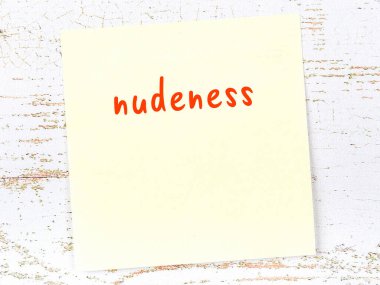 Tahta duvardaki sarı yapışkan notta elle yazılmış çıplaklık var.