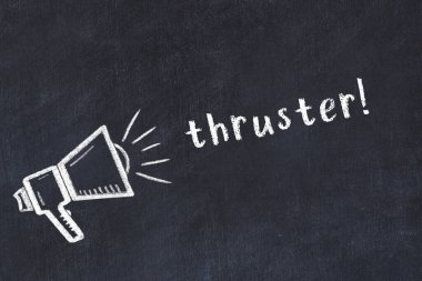 Hoparlörün tebeşir çizimi ve siyah masanın üzerine el yazısıyla yazılmış yazı roketi.