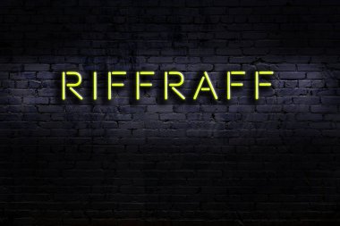 Üzerinde tuğla duvara karşı işlenmiş ayak takımı yazılı neon levhası. Gece görünümü