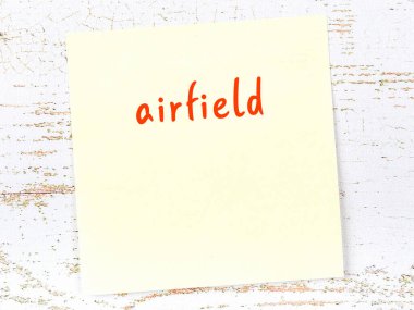 Havaalanını hatırlatma kavramı. Tahta duvarda üzerinde yazı olan sarı yapışkan kağıt.