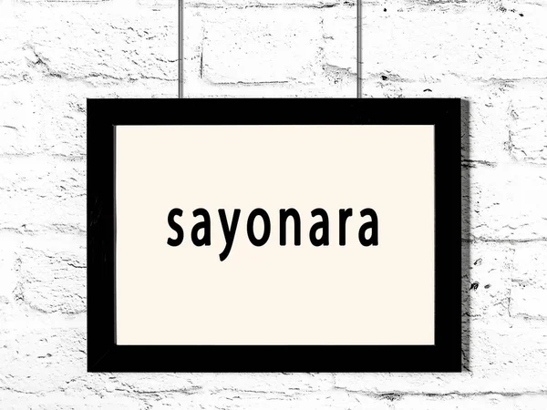 白いレンガの壁に掛け碑文Sayonaraと黒い木製のフレーム — ストック写真