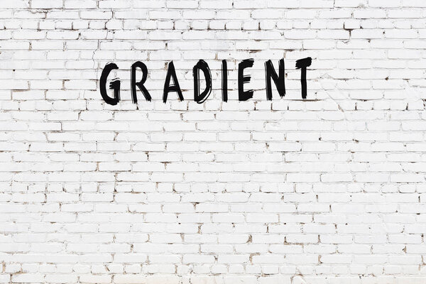 Inscription gradient written with black paint on white brick wall.