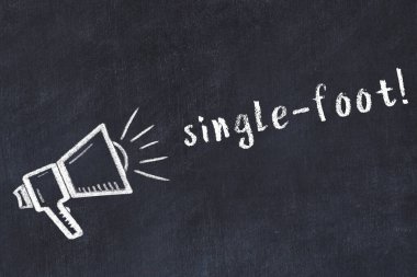 Hoparlörün tebeşir çizimi ve tek ayak siyah masanın üzerine yazılmış el yazısı.