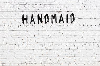 Beyaz tuğla duvara siyah boya ile yazılmış bir hizmetçi..