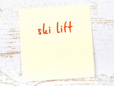 Kayak kaldırmayı hatırlatma kavramı. Tahta duvarda üzerinde yazı olan sarı yapışkan kağıt.