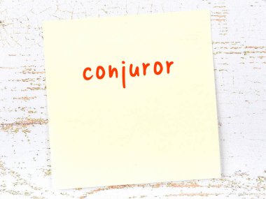 Sihirbaz hakkında hatırlatma kavramı. Tahta duvarda üzerinde yazı olan sarı yapışkan kağıt.