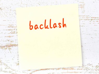 Ters tepkiyi hatırlatma kavramı. Tahta duvarda üzerinde yazı olan sarı yapışkan kağıt.