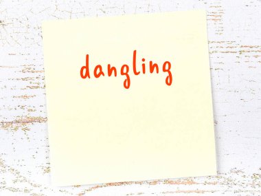 Tahta duvarda asılı sarı yapışkan bir not ve el yazısıyla yazılmış bir yazı var.