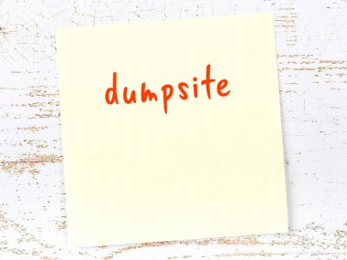 Çöplük hakkında hatırlatma kavramı. Tahta duvarda üzerinde yazı olan sarı yapışkan kağıt.