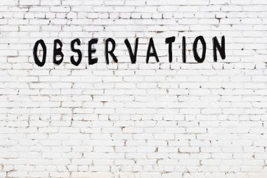 Beyaz tuğla duvara siyah boya ile yazılmış bir yazıt gözlemi.