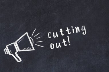 Hoparlörün tebeşir çizimi ve siyah masada kesilen el yazısıyla yazılmış yazı