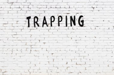 Beyaz tuğla duvara siyah boya ile yazılmış bir yazı..