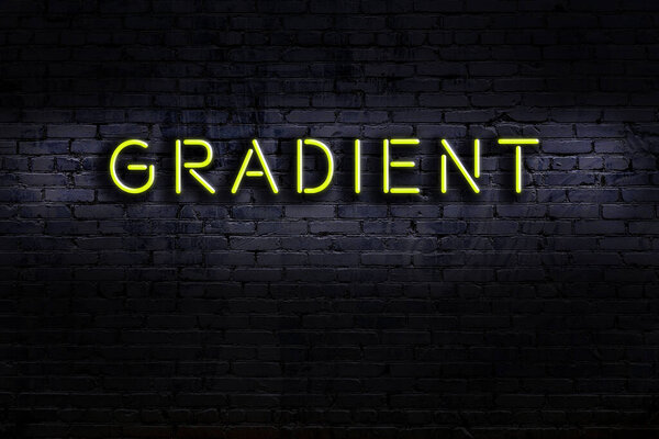 Neon sign with inscription gradient against brick wall. Night view