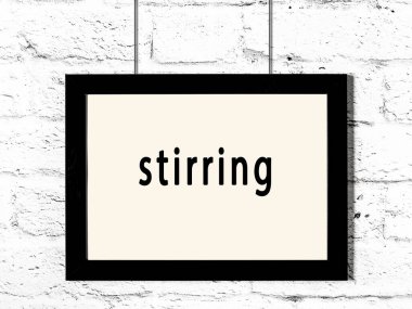 Siyah ahşap çerçeve, beyaz tuğla duvarda yazılar asılı. 