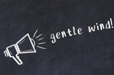 Hoparlörün tebeşir çizimi ve el yazısıyla yazılmış yazı. Siyah masanın üzerine hafif bir rüzgar.