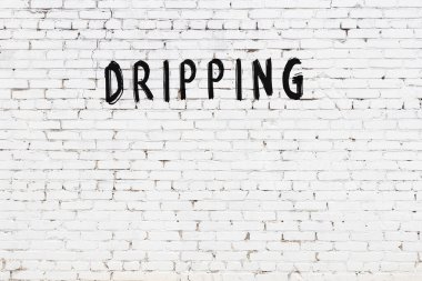 Üzerinde siyah boya olan beyaz tuğla bir duvar.