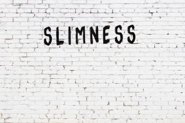 Beyaz tuğla duvara siyah boya ile yazılmış ince yazılar..