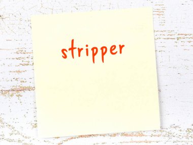 Tahta duvardaki sarı yapışkan notta el yazısıyla yazılmış striptizci.