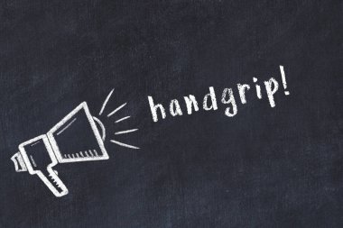 Hoparlörün tebeşir çizimi ve siyah masanın üzerine el yazısıyla yazılmış el yazısı.