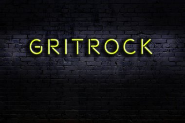 Duvarda yazı yazan neon levhası var. Gece görünümü