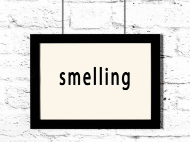 Siyah ahşap çerçeve, beyaz tuğla duvarda yazı kokusu var. 