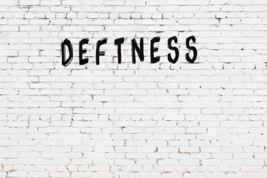 Beyaz tuğla duvara siyah boya ile yazılmış bir yazı..