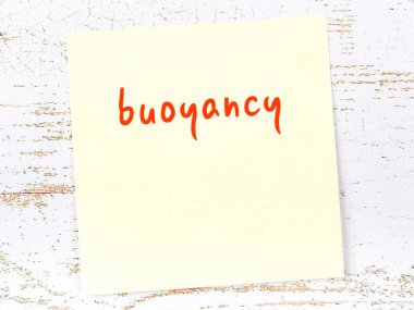 Tahta duvarda el yazısıyla yazılmış yüzdürme özelliği olan sarı yapışkan bir not.