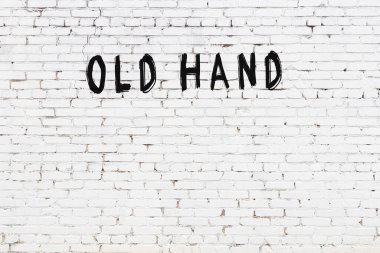 Yazı, beyaz tuğla duvara siyah boya ile yazılmış..