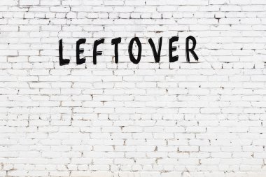 Beyaz tuğla duvara siyah boya ile yazılmış bir yazı..