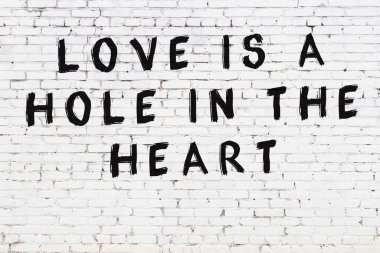 Üzerinde mantıklı alıntıların yazılı olduğu siyah boyanmış beyaz tuğla duvar.