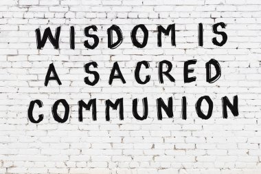 Beyaz tuğla duvar ve bilgece alıntıların yazılı olduğu siyah yazı.