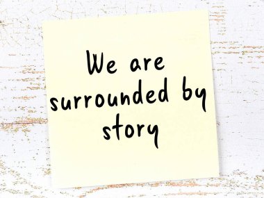 Tahta duvarda asılı sarı yapışkan nota elle yazılmış bilgece bir alıntı.