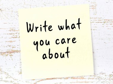 Tahta duvarda el yazısı motivasyon alıntısı olan sarı yapışkan not