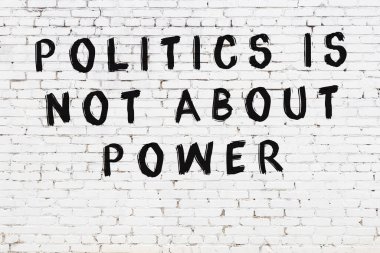 Beyaz tuğla duvar ve bilgece alıntıların yazılı olduğu siyah yazı.