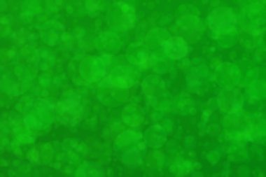 Parlak yeşil lekeler arka planda bulanık. Odaklanamayan soyut bokeh