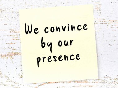 Tahta duvarda asılı sarı yapışkan nota elle yazılmış bilgece bir alıntı.