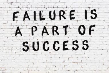 Üzerinde mantıklı alıntıların yazılı olduğu siyah boyanmış beyaz tuğla duvar.