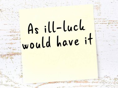 Sarı yapışkan not, ahşap duvarda el yazısıyla yazılmış zekice bir alıntıyla.