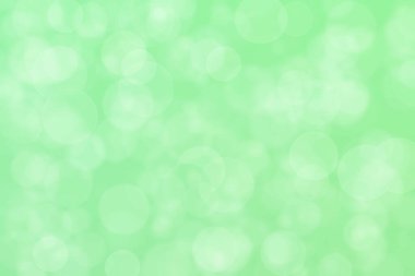 Çember şeklindeki bokeh noktalarıyla açık yeşil soyut odaklanmış arkaplan